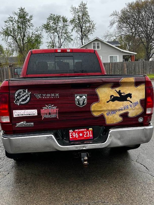 The back of a red dodge ram truck with stickers on it