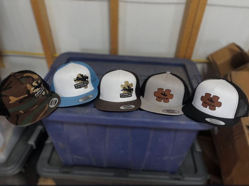 Five trucker hats with logos, various colors, resting on a blue storage bin.