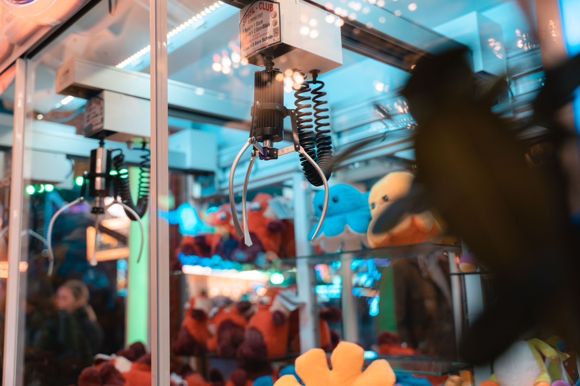 A machine is holding a stuffed animal in a claw machine.