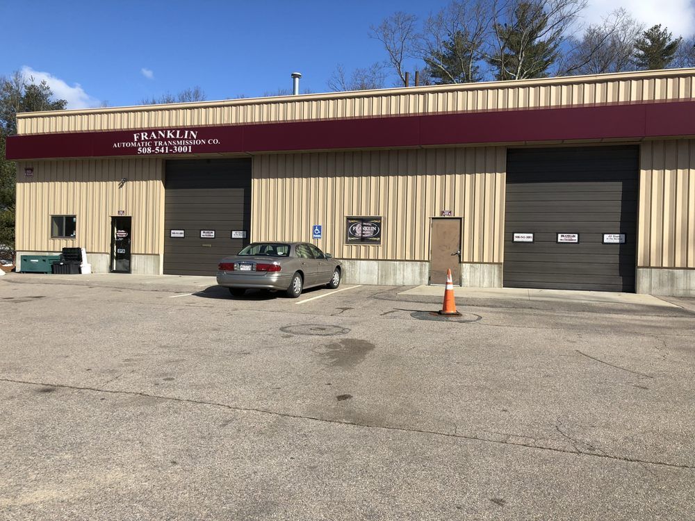 A car is parked in front of a building that says franklin | Franklin Transmission and Auto Care