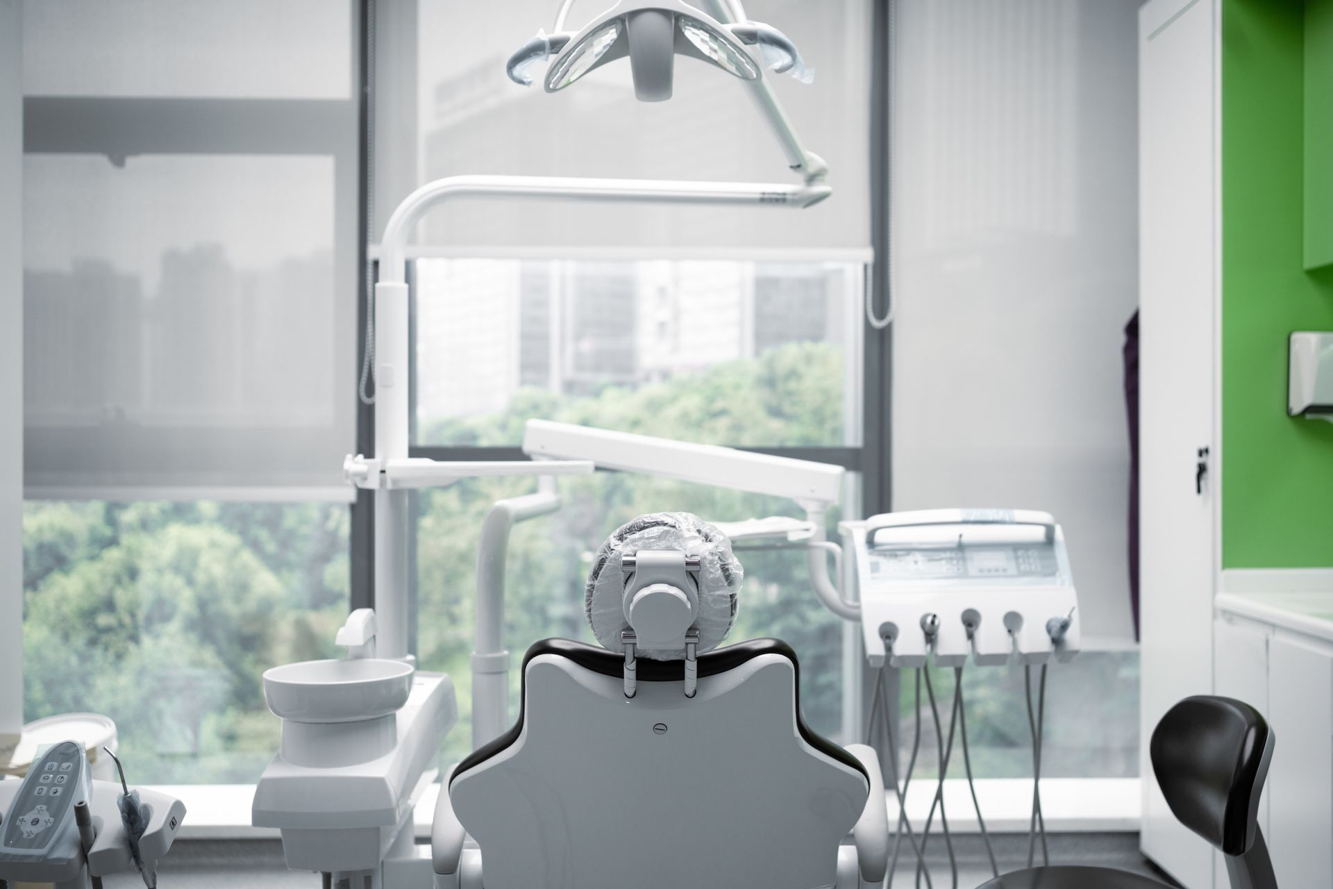 Dentist chair in a bright, modern room, overlooking a cityscape.