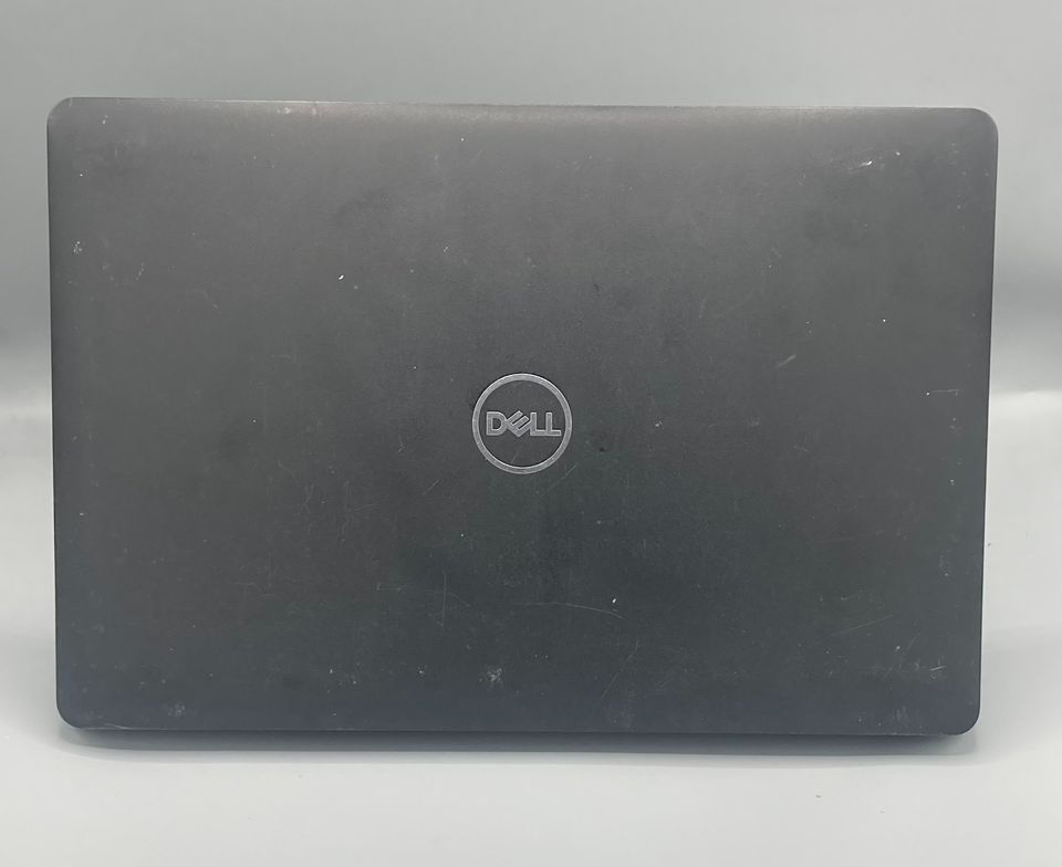 Black Dell laptop, open, facing the viewer, on a light surface. Keyboard visible with a dark screen.
