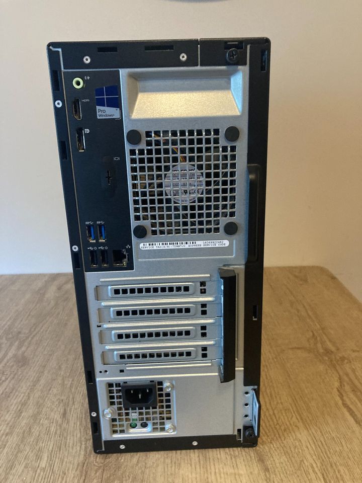 Dell OptiPlex 3040 tower desktop computer on a wooden table, black front with Dell logo and ports.