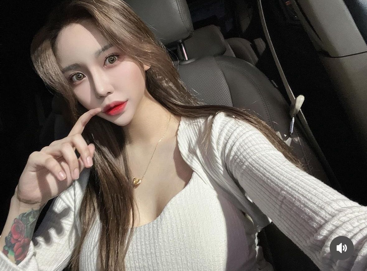 A woman is taking a selfie in the back seat of a car.