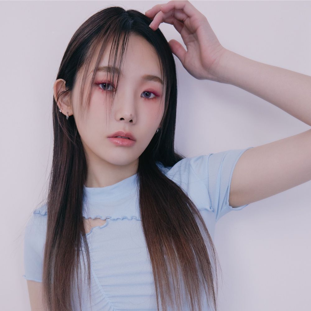 A woman with long hair is wearing a light blue shirt