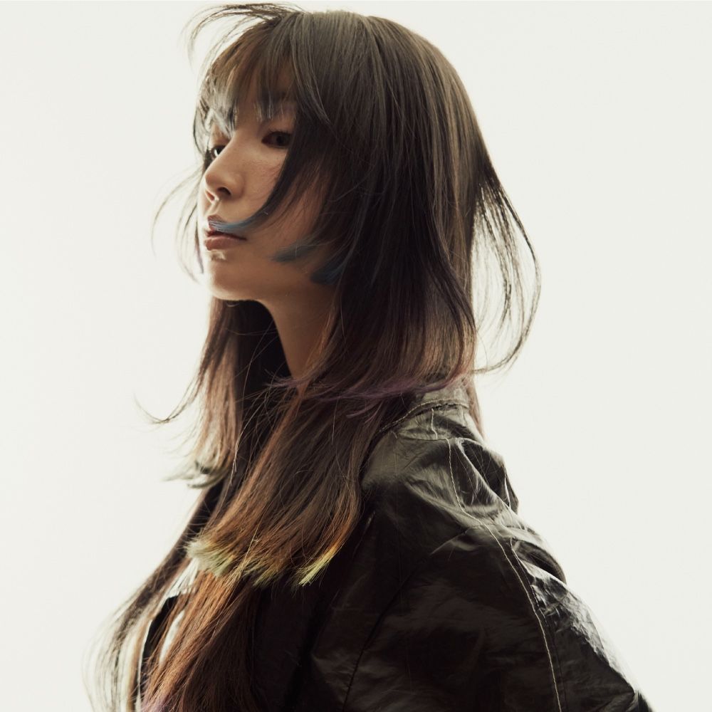 A woman with long hair is wearing a black jacket