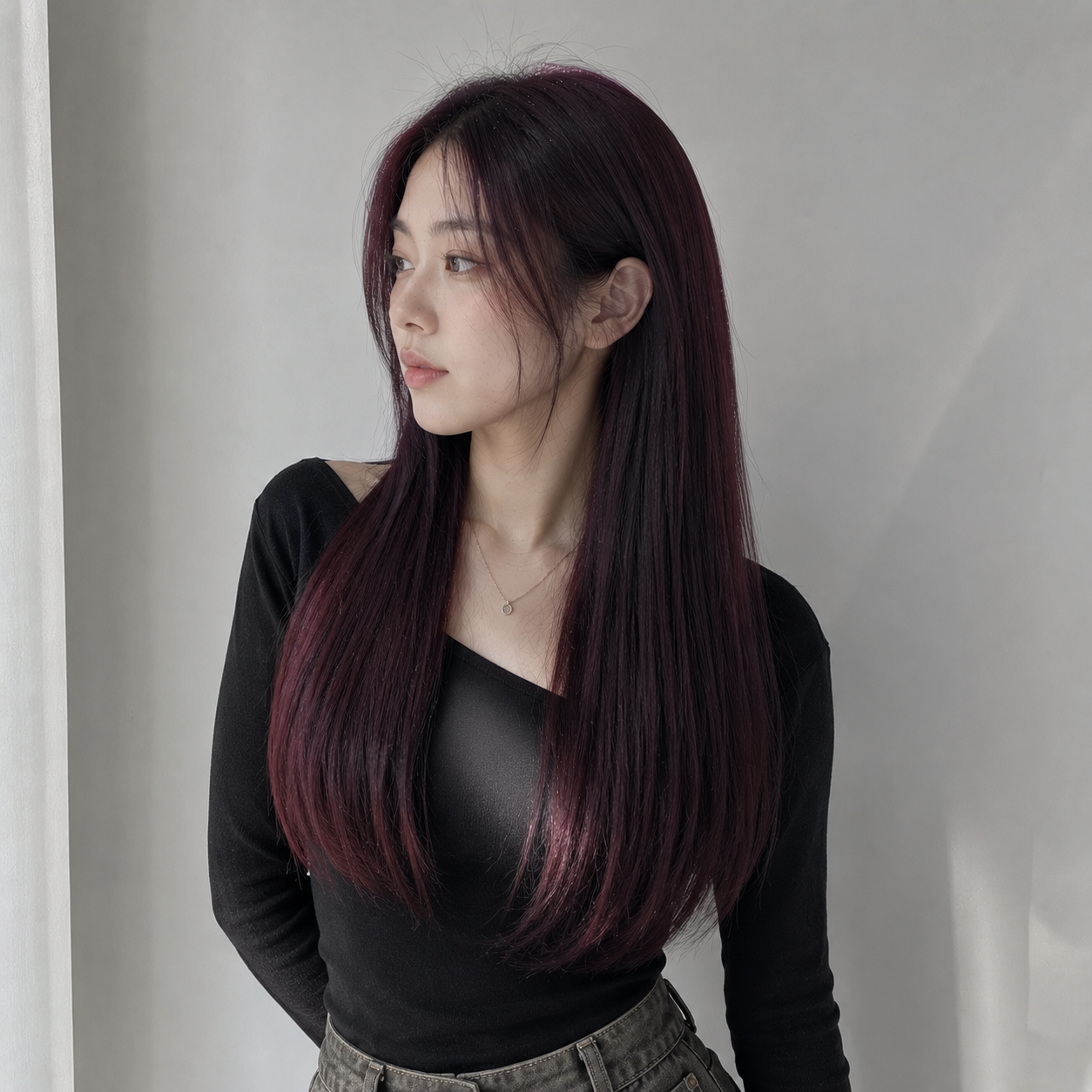 A woman with long black hair is wearing a white t-shirt and black jeans.