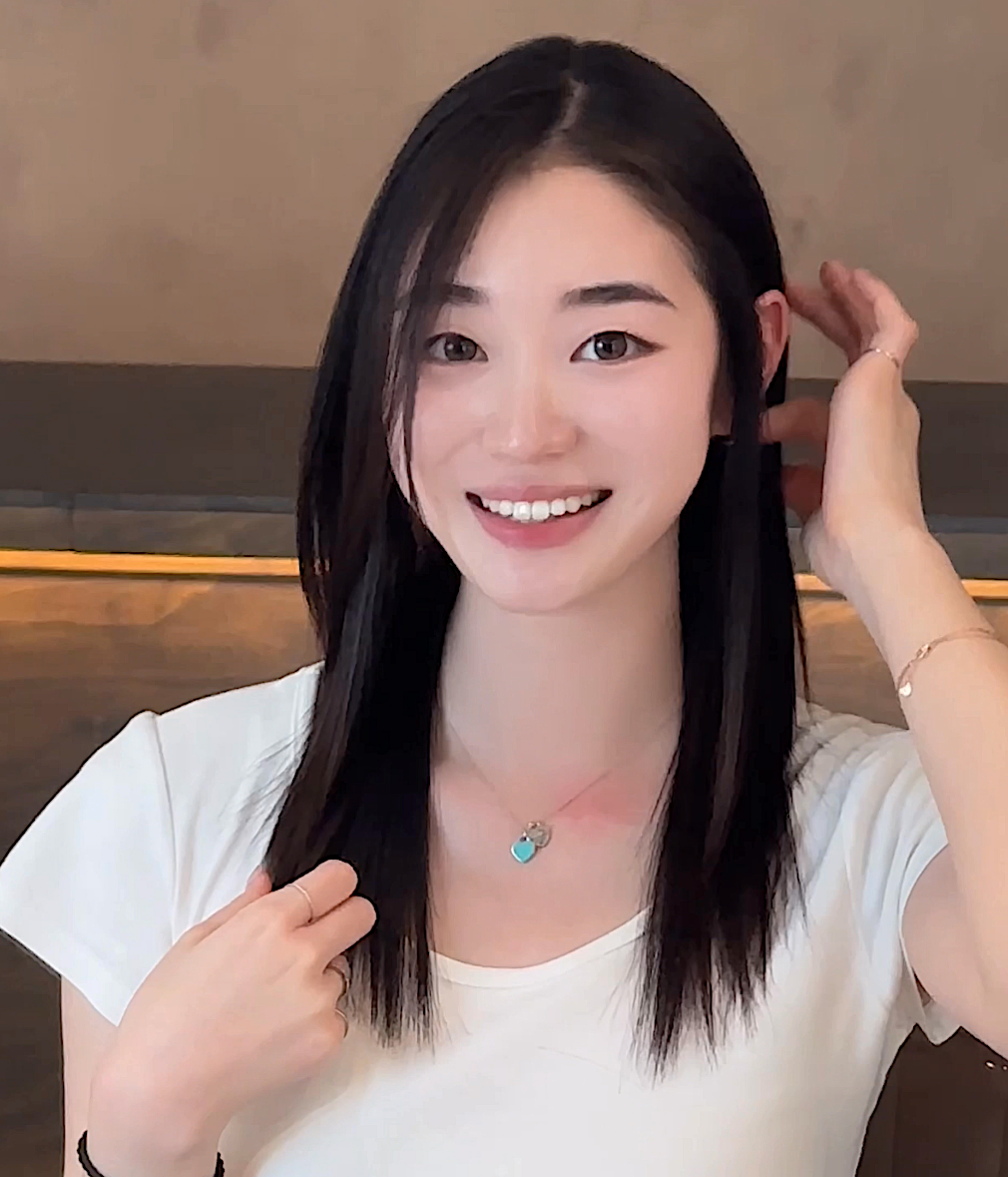 A woman with long hair is wearing a light blue shirt