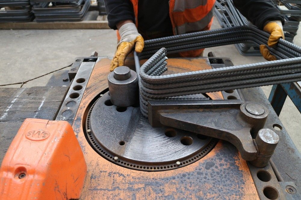 A Worker Bends Rebar with A Machine in A Factory Setting — SAE Engineering in Mount Sheridan, QLD