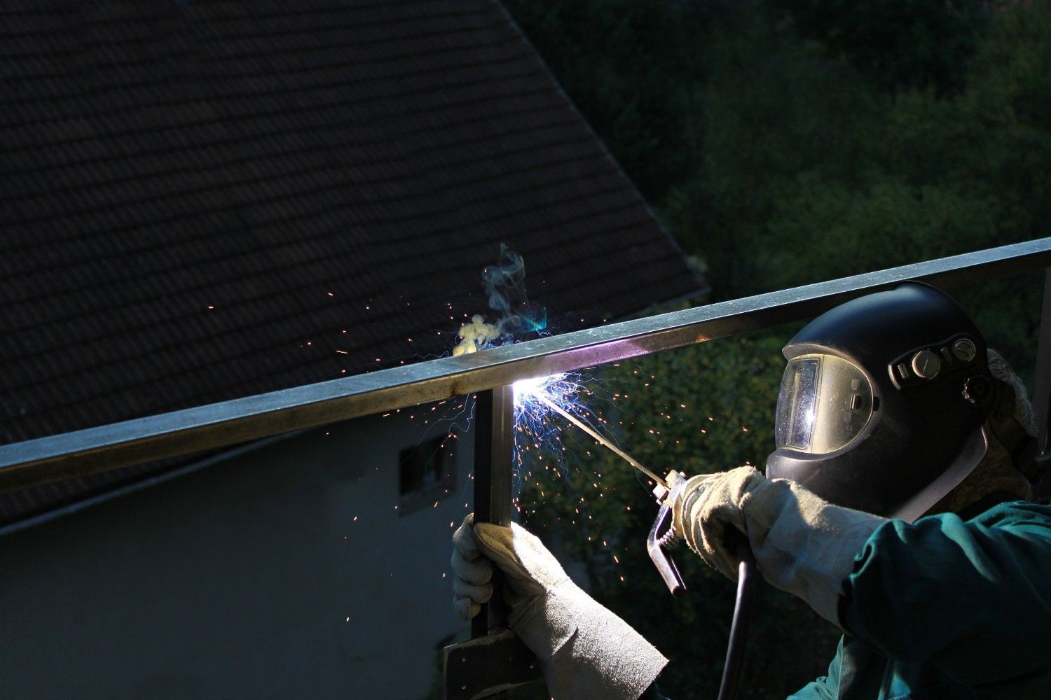 Welder in A Helmet Is Welding a Metal Structure Outdoors — SAE Engineering in Mount Sheridan, QLD