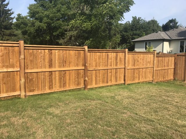 Tall wood privacy fence surrounding a residential backyard
