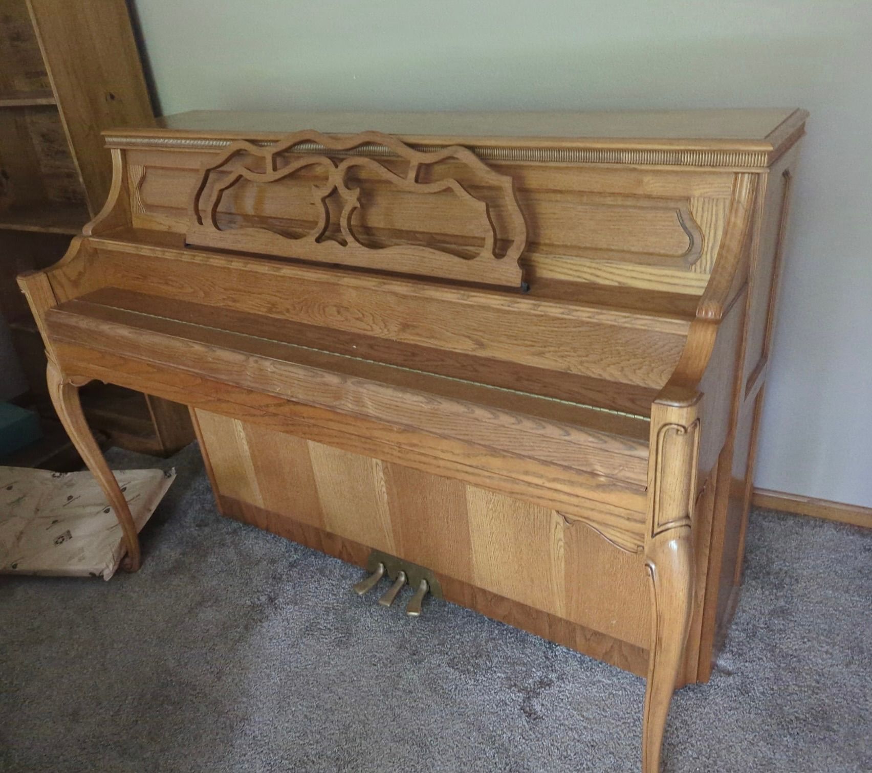 Woman and older woman smiling, indoors. Woman in red shirt, other in navy blazer.