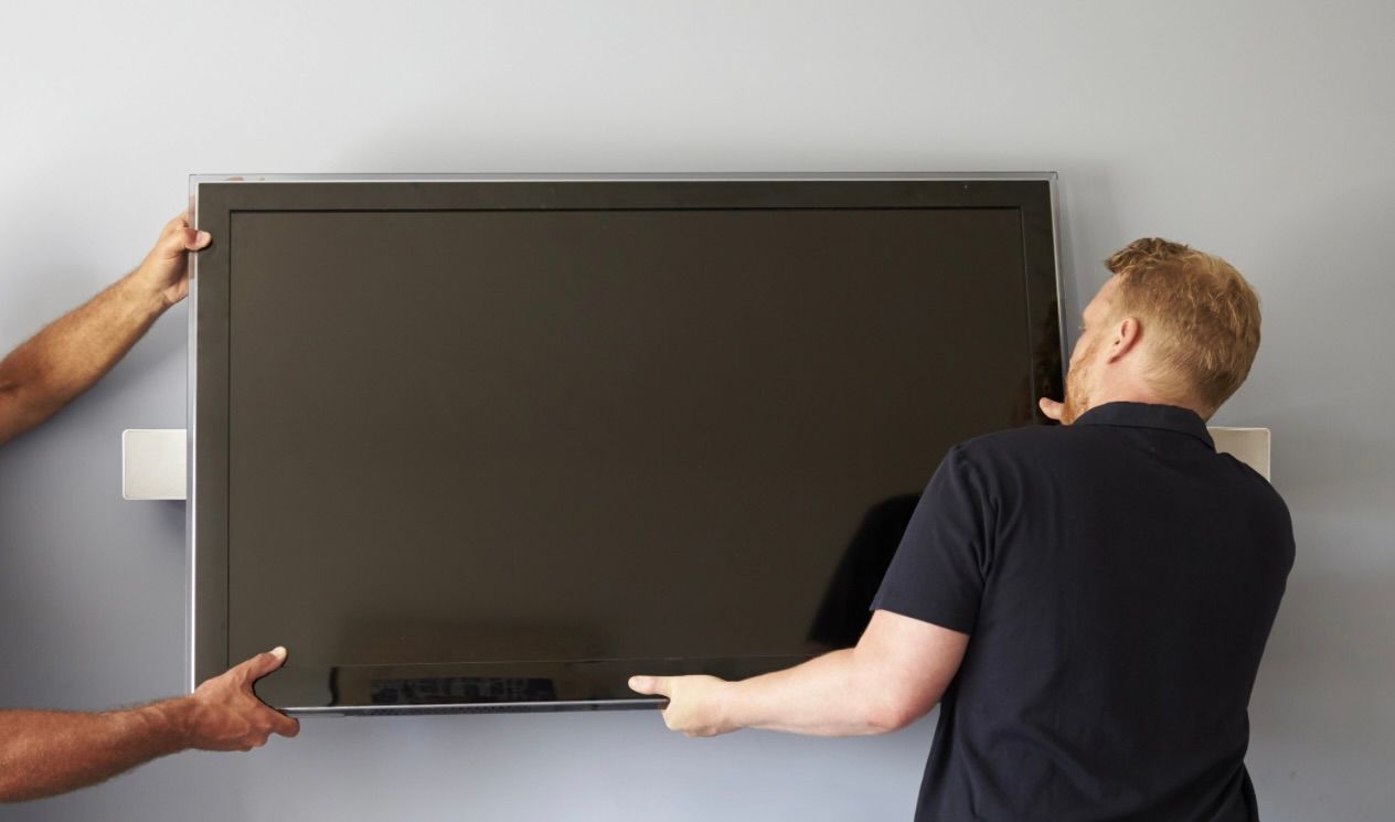 Team member mounting a tv on the wall