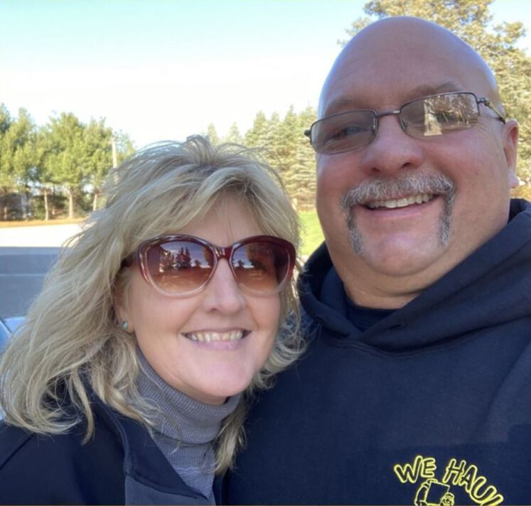 Woman and older woman smiling, indoors. Woman in red shirt, other in navy blazer.