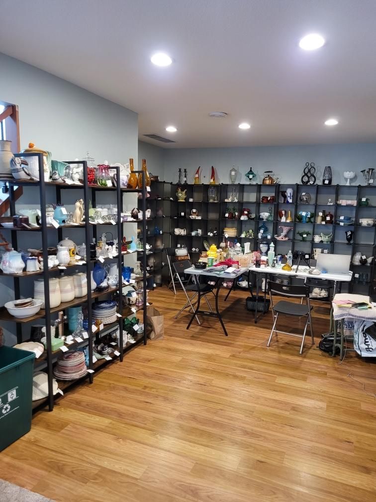 A store interior filled with shelves of various items, wooden floor, and bright lighting.