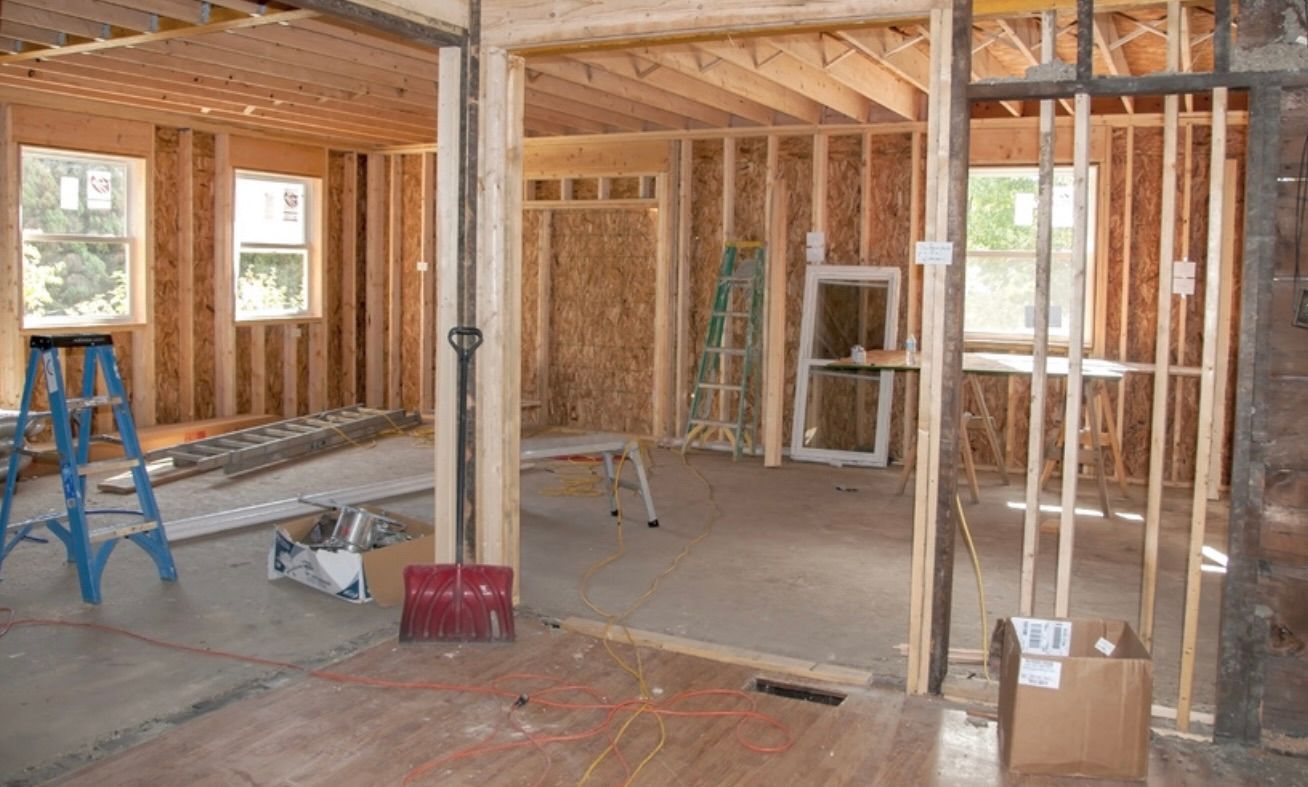 Woman and older woman smiling, indoors. Woman in red shirt, other in navy blazer.