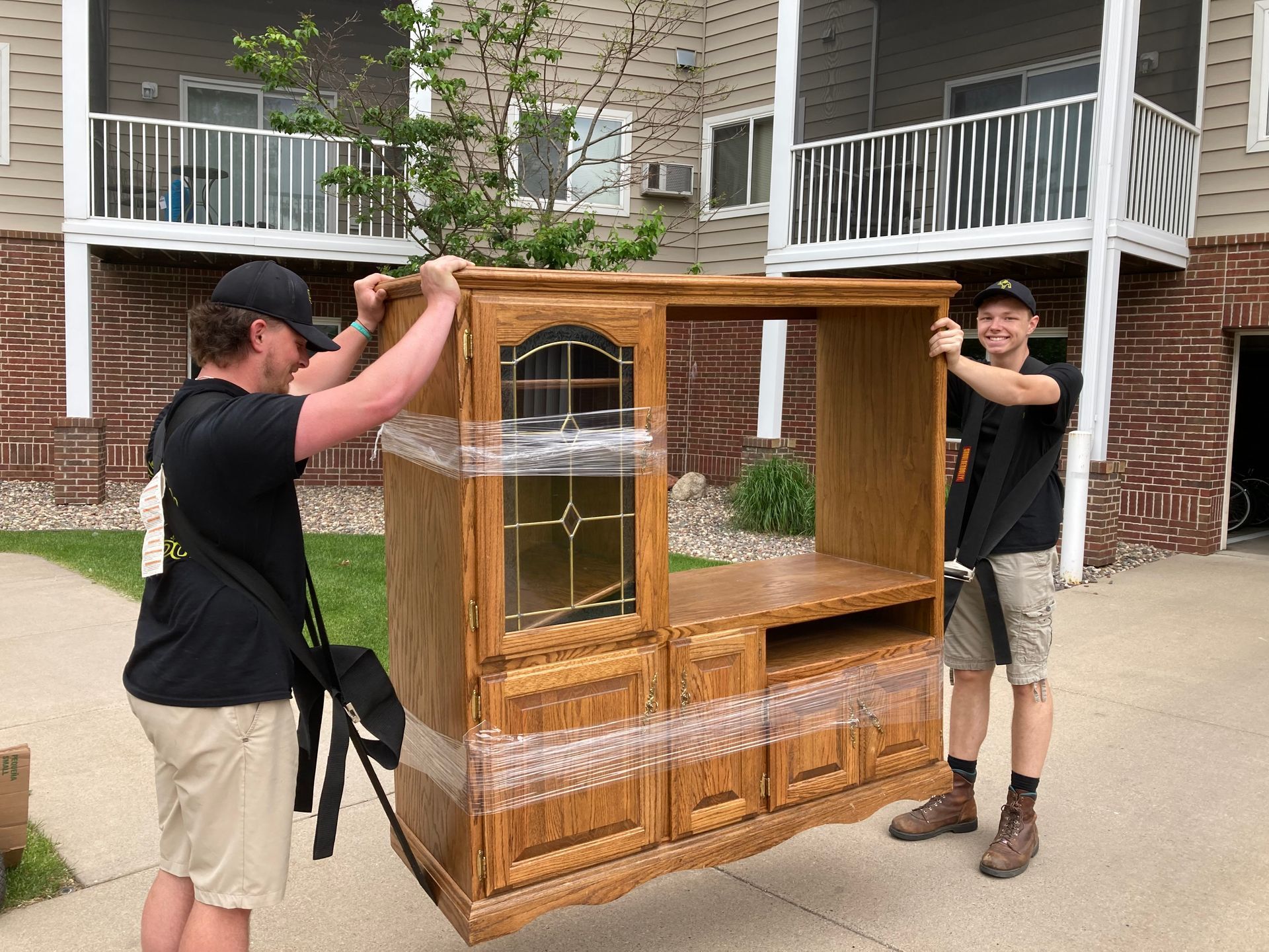 Woman and older woman smiling, indoors. Woman in red shirt, other in navy blazer.
