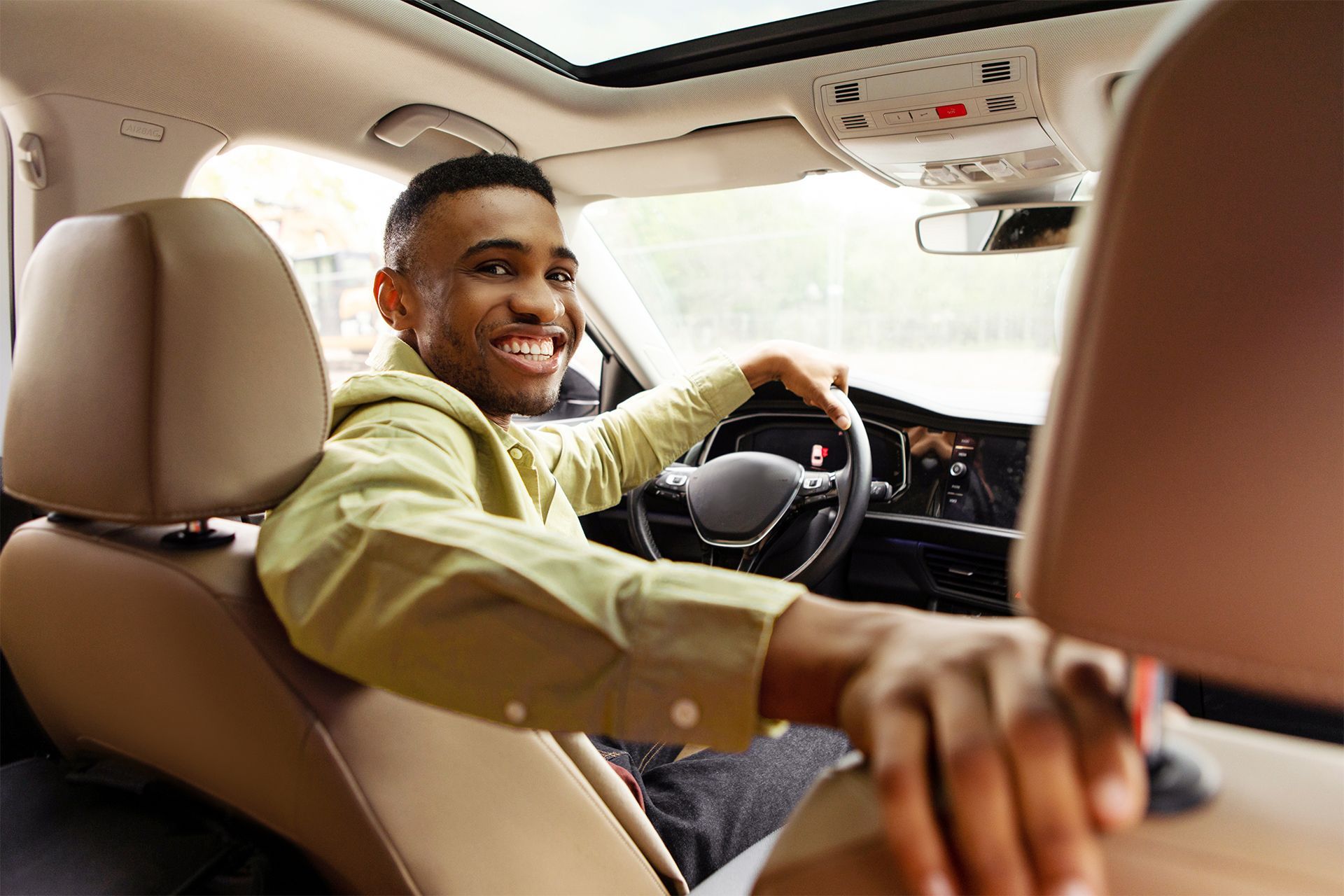 A wheelchair sits on a ramp extending from the open back of a red van.
