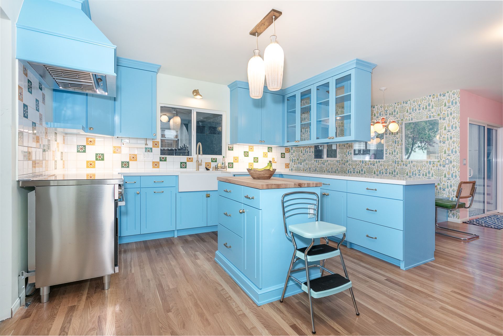 A Vibrant Kitchen:
Complete kitchen renovation featuring custom design and vibrant colors, complete with a peninsula, Island, breakfast nook, and floor-to-ceiling wall of cabinets. The space also boasts a ceramic tile backsplash, quartz and butcher block counters, and oak wood flooring.