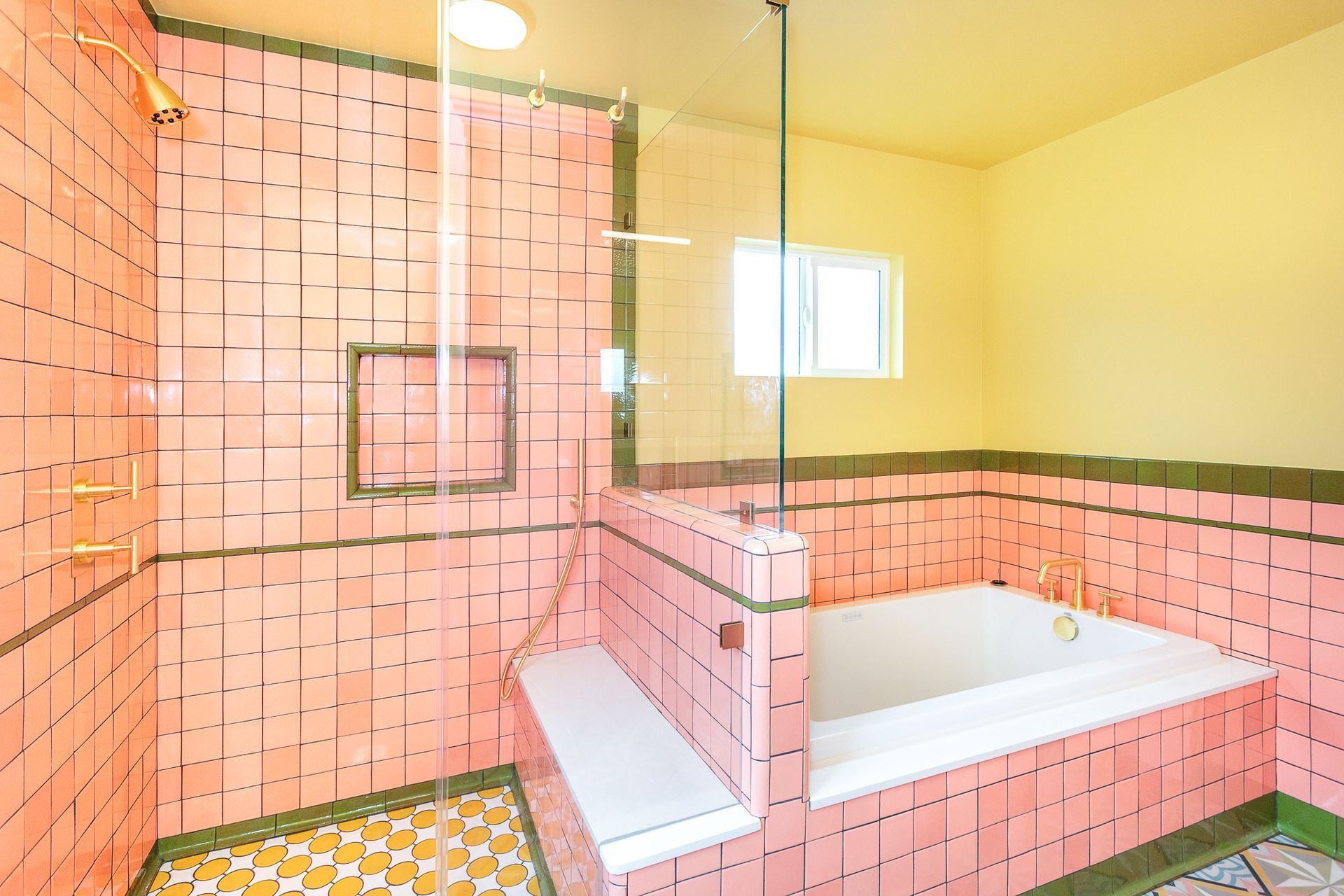 Vibrant bathroom, featuring custom ceramic tile, a bench, a shampoo niche, a built-in tub, and a separate shower.