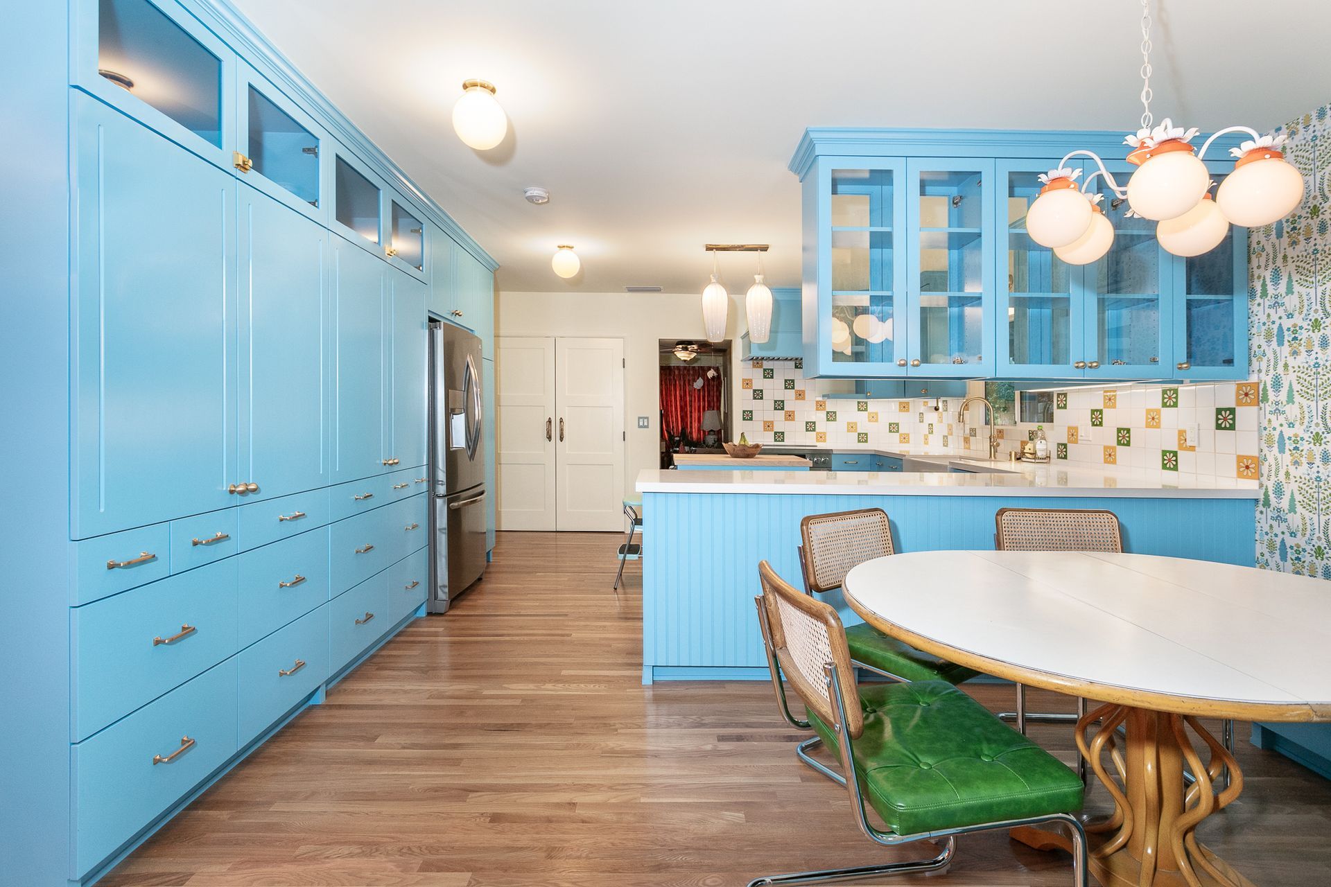A Vibrant Kitchen:
Complete kitchen renovation featuring custom design and vibrant colors, complete with a peninsula, Island, breakfast nook, and floor-to-ceiling wall of cabinets. The space also boasts a ceramic tile backsplash, quartz and butcher block counters, and oak wood flooring.