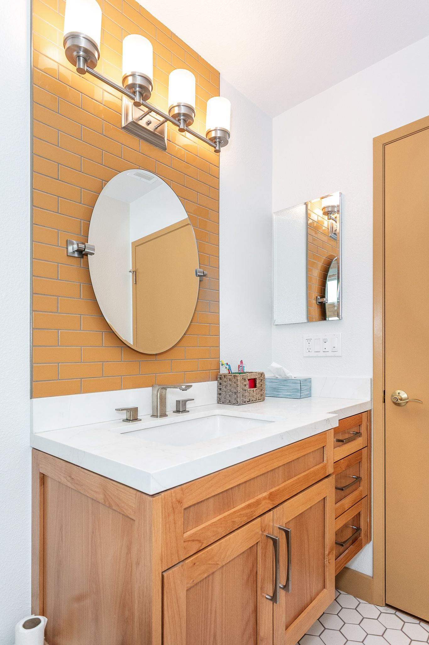 Guest bathroom remodel featuring custom ceramic orange tile for the tub walls and behind the vanity mirror, along with a custom-built floating vanity.