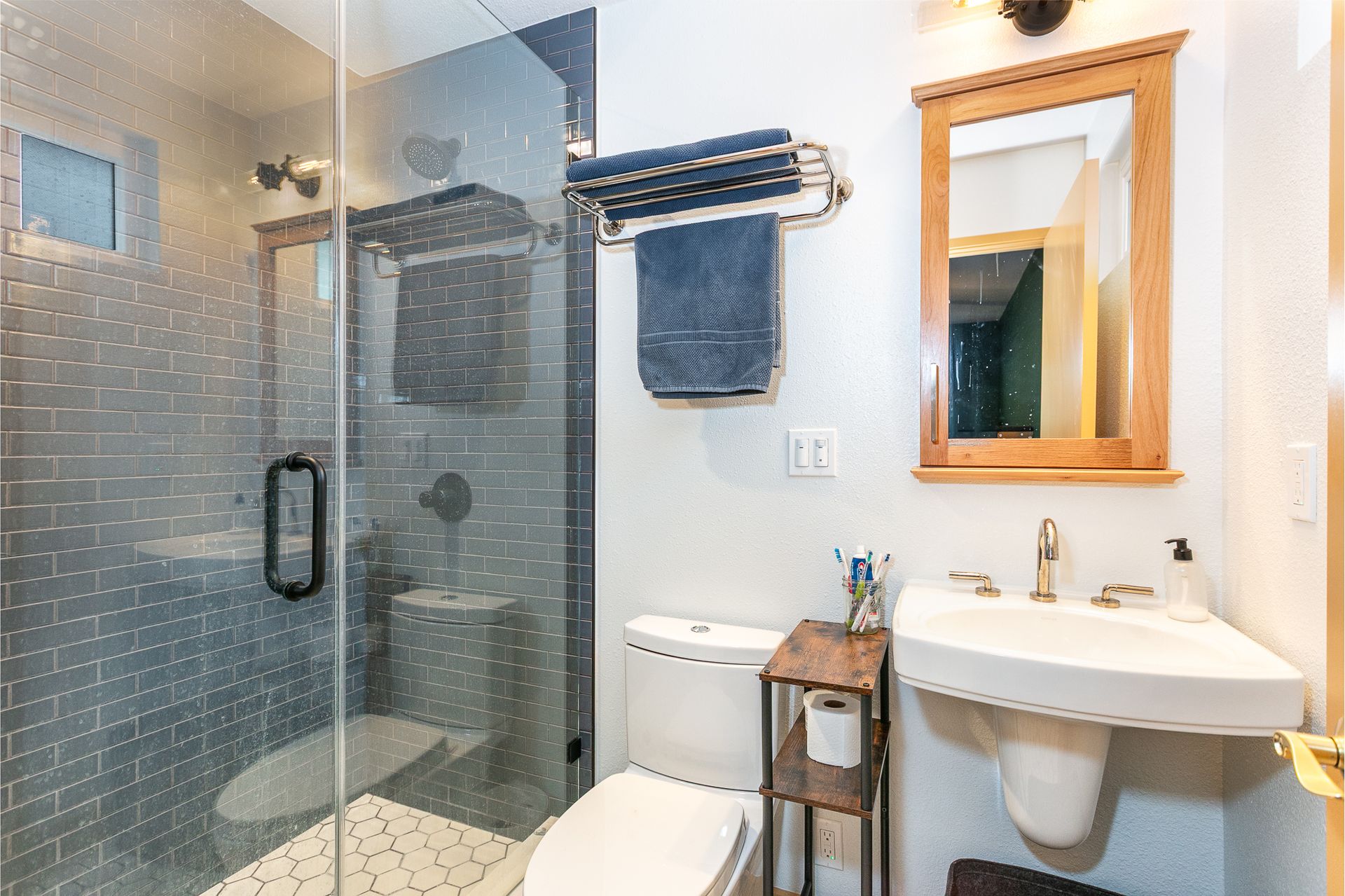 Small master bathroom with a custom tile shower, a wall-mount sink, a custom medicine cabinet, and a frameless shower door.