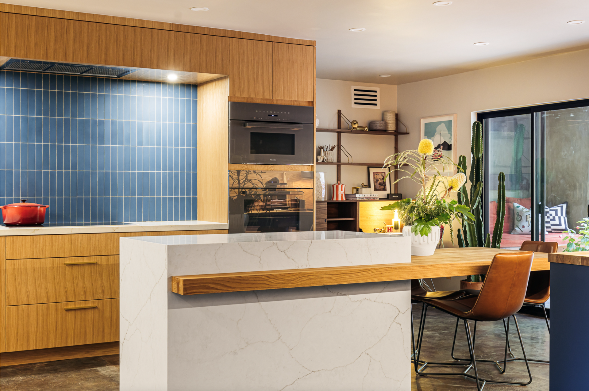 Modern kitchen with blue tile backsplash, wood cabinets, and island with wooden counter.