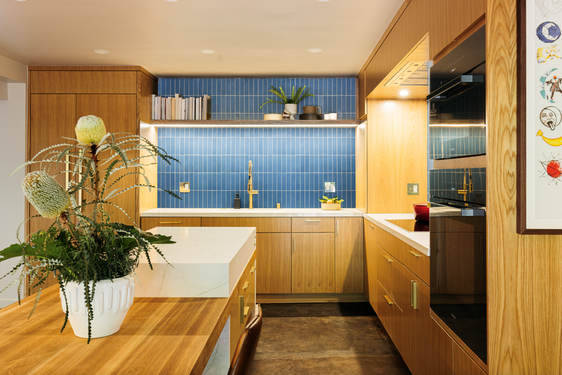 Modern kitchen with blonde wood cabinets, blue tile backsplash, and large island.