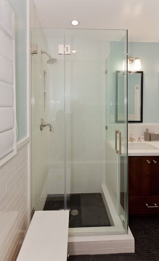 Modern bathroom with glass shower enclosure, dark floor, and white vanity.