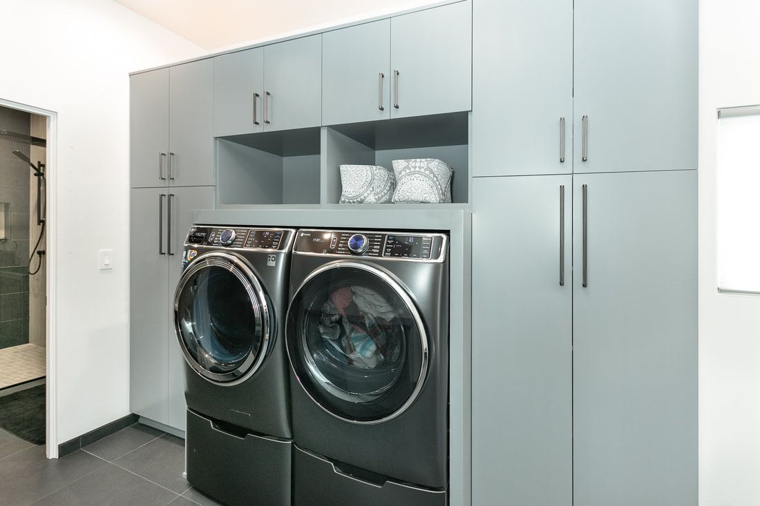 Laundry room with gray cabinets, washer, and dryer.