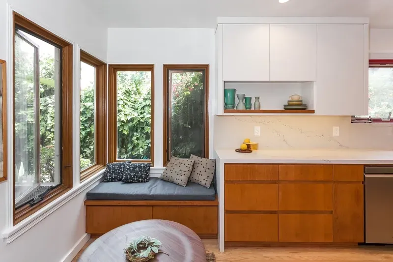 Kitchen with window seat, featuring wood cabinets, white countertops, and a stainless steel appliance.