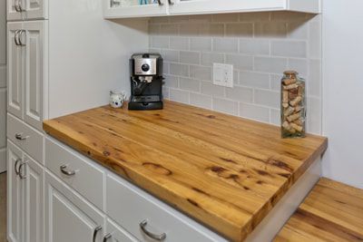 Wooden countertop with coffee machine and cabinet in kitchen.