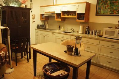 Kitchen with wooden cabinets, dining table, and a dark cabinet on the left.