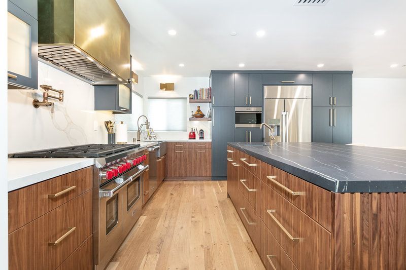 Modern kitchen with wood cabinets, stainless steel appliances, and large island.