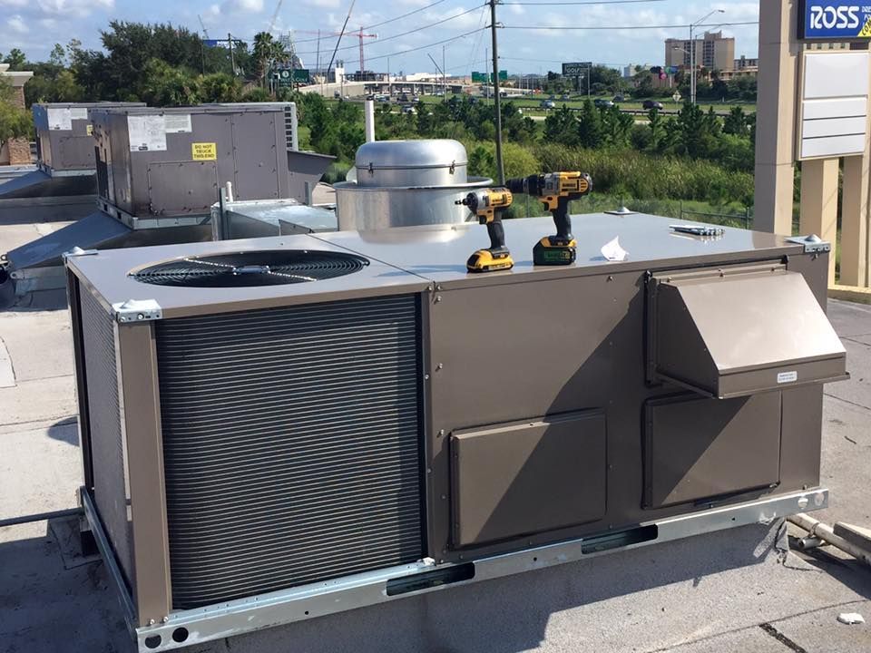 HVAC unit on a roof with two drills, next to a Ross sign