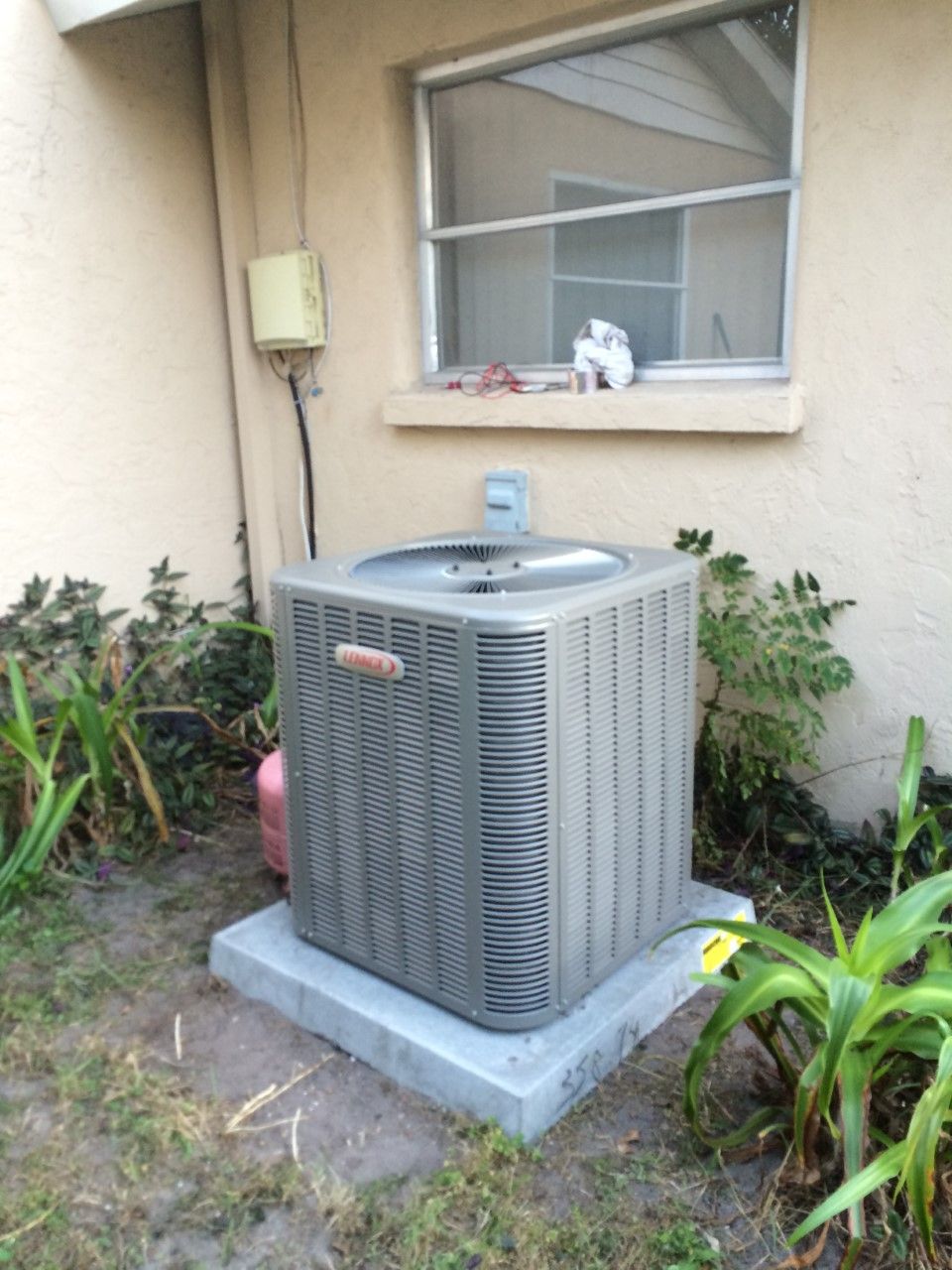 Air conditioner unit outside a building next to a window