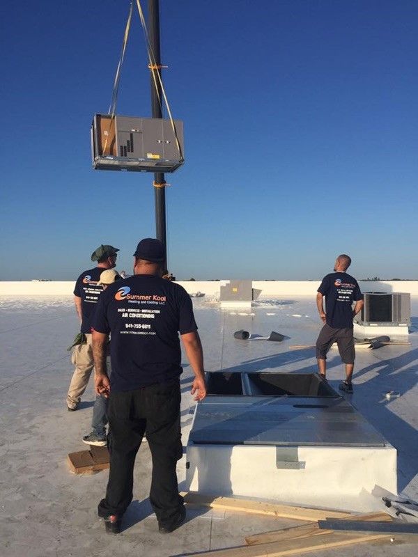 Workers on a rooftop installing HVAC equipment