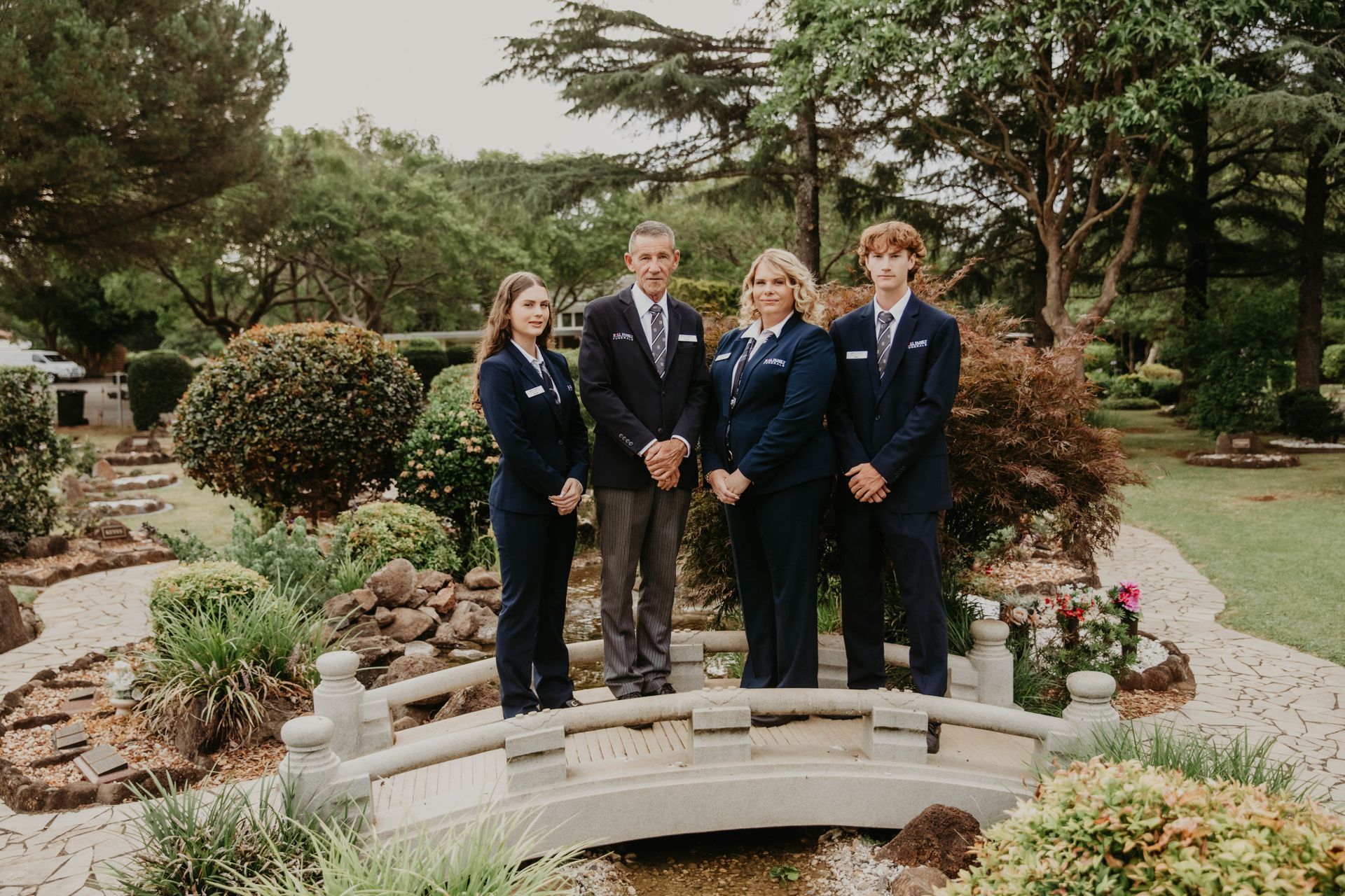 A Woman is Holding the Hand of Another Woman While Sitting at a Table — Bull Family Funerals in Goondiwindi, QLD