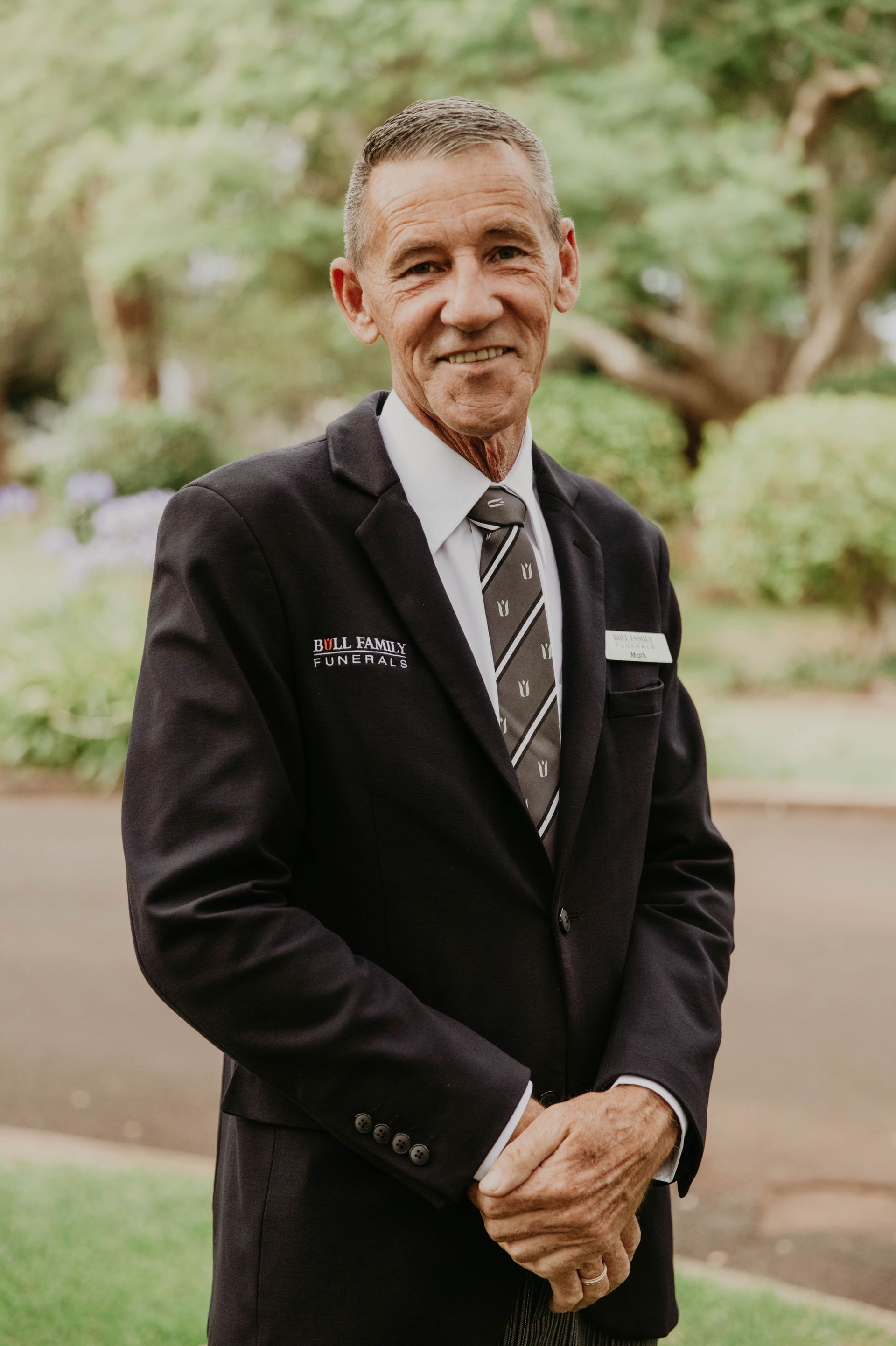 Mark Standing Next To White Car With Door Open — Bull Family Funerals in Inglewood, QLD
