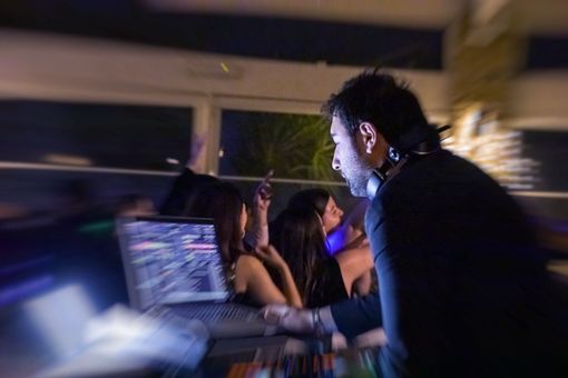 Gli ospiti ballano durante un ricevimento formale, con un DJ e una calda illuminazione da sala da ballo.