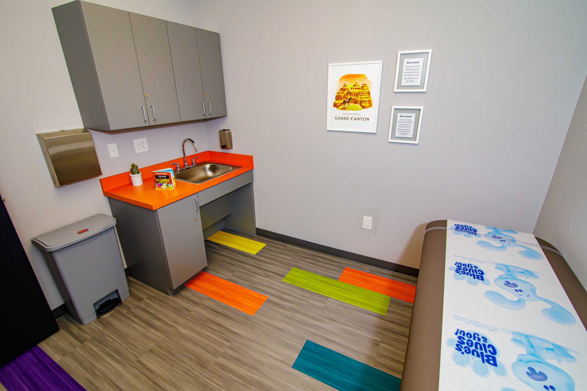A room with a sink , cabinets , and a bed.