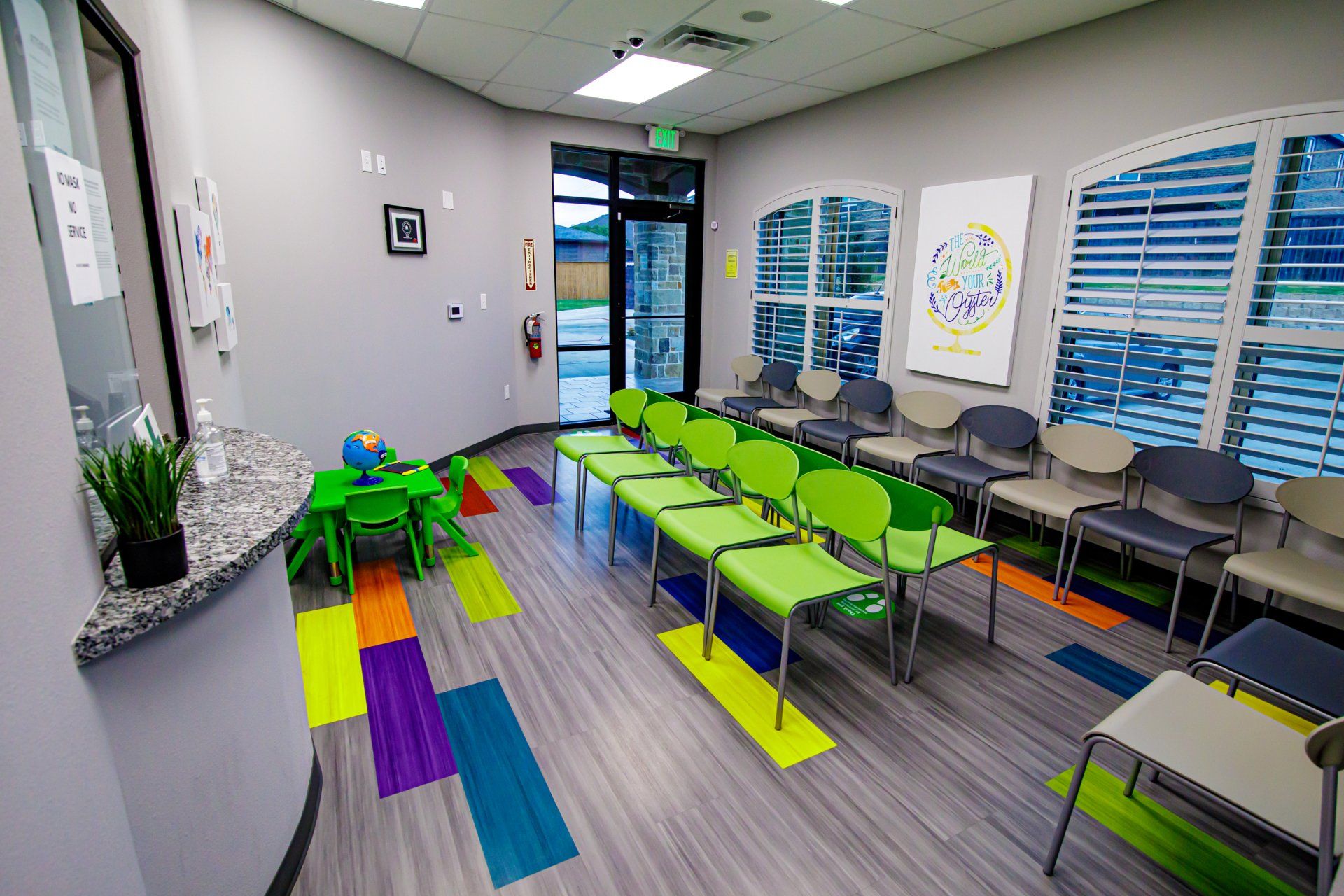 A waiting room with a lot of chairs and a table.