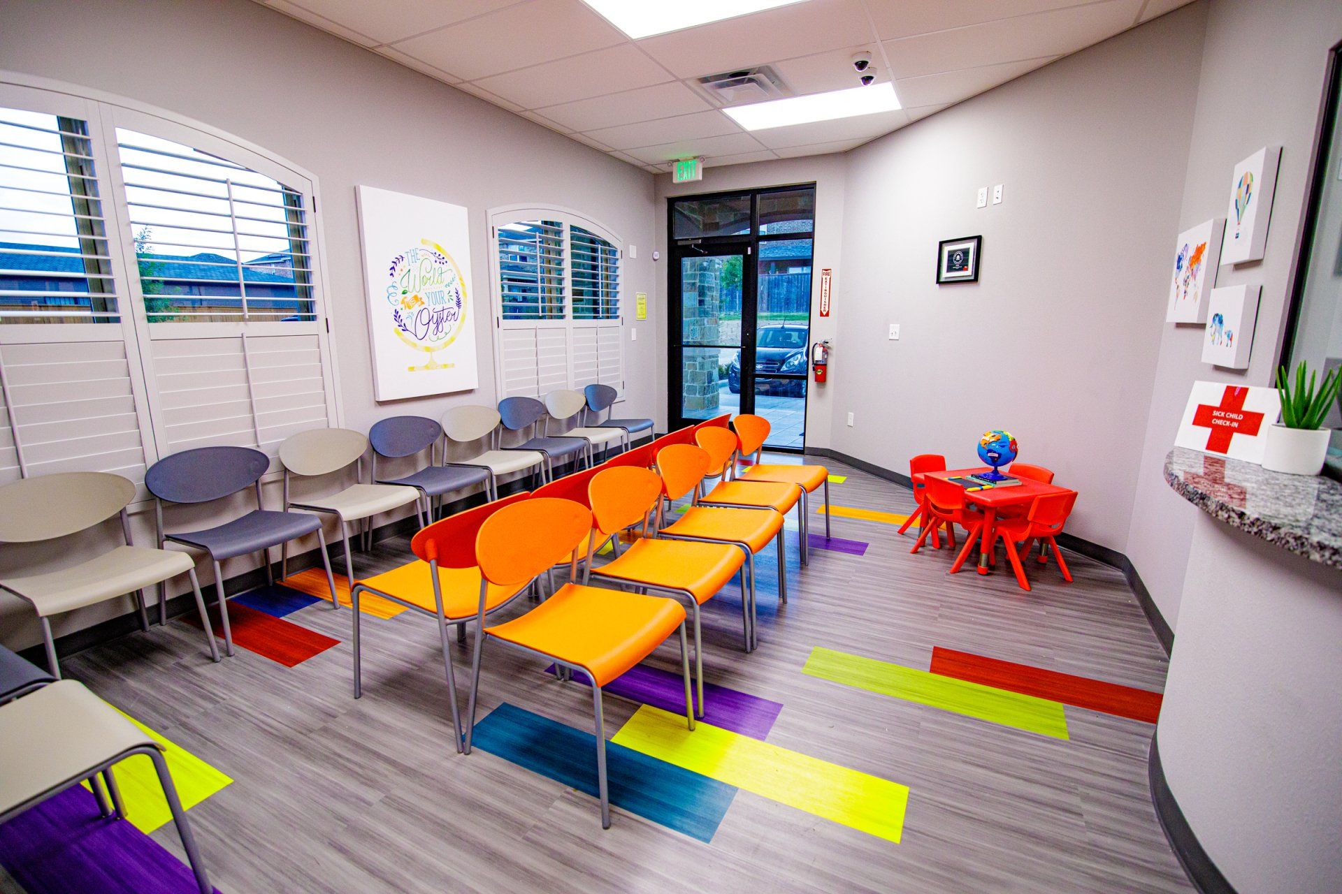 A waiting room with colorful chairs and a table for children.