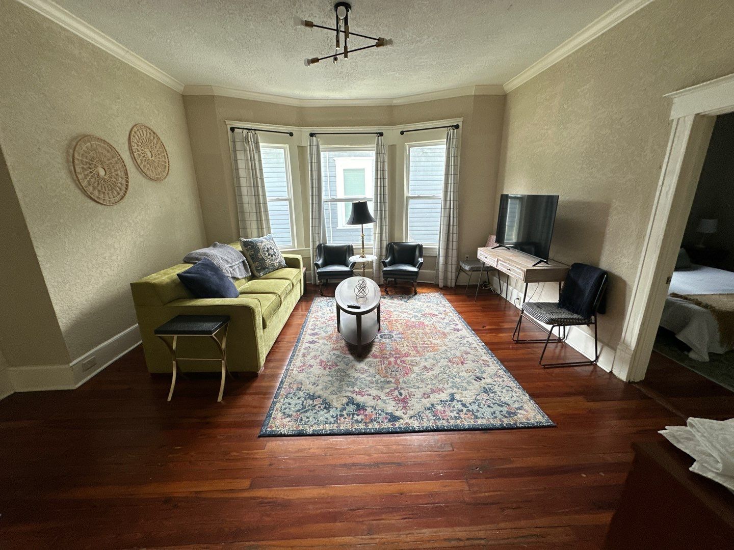 A living room with a couch , chairs , and a television.