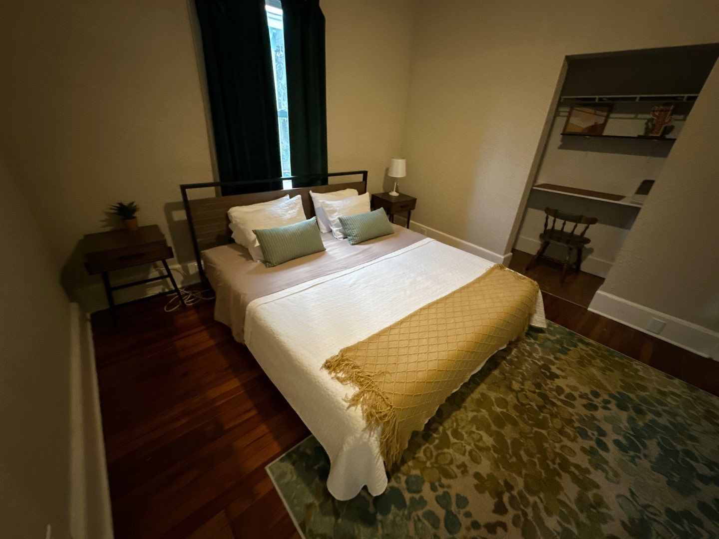 A bedroom with a bed and a rug in it