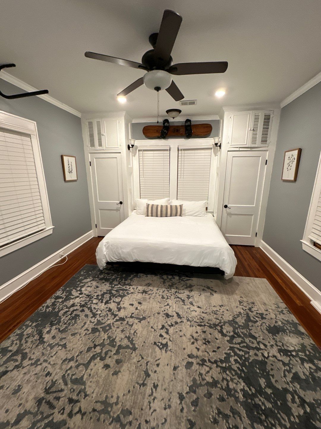 A bedroom with a bed and a ceiling fan.