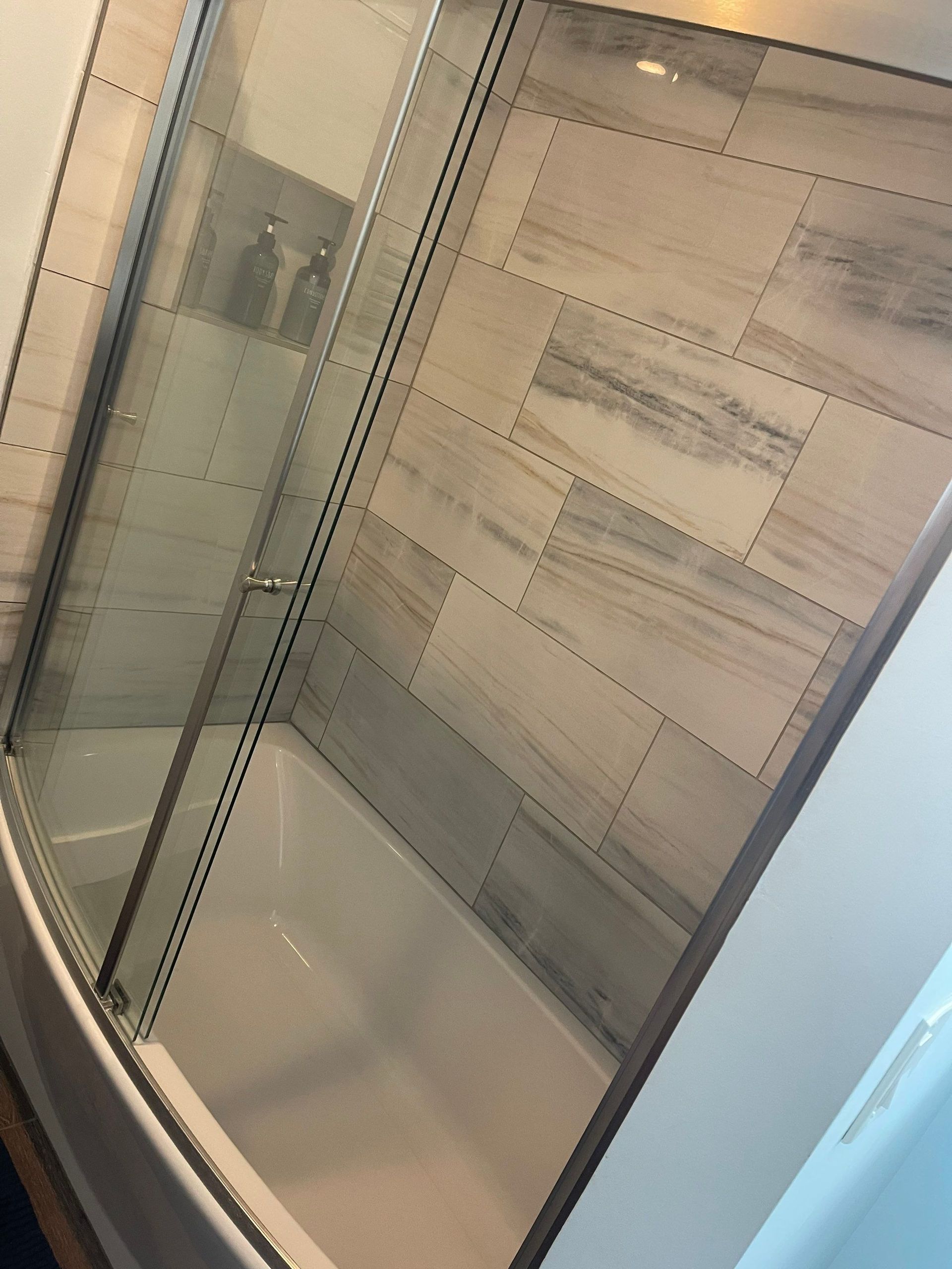 A bathroom with a bathtub and a shower stall