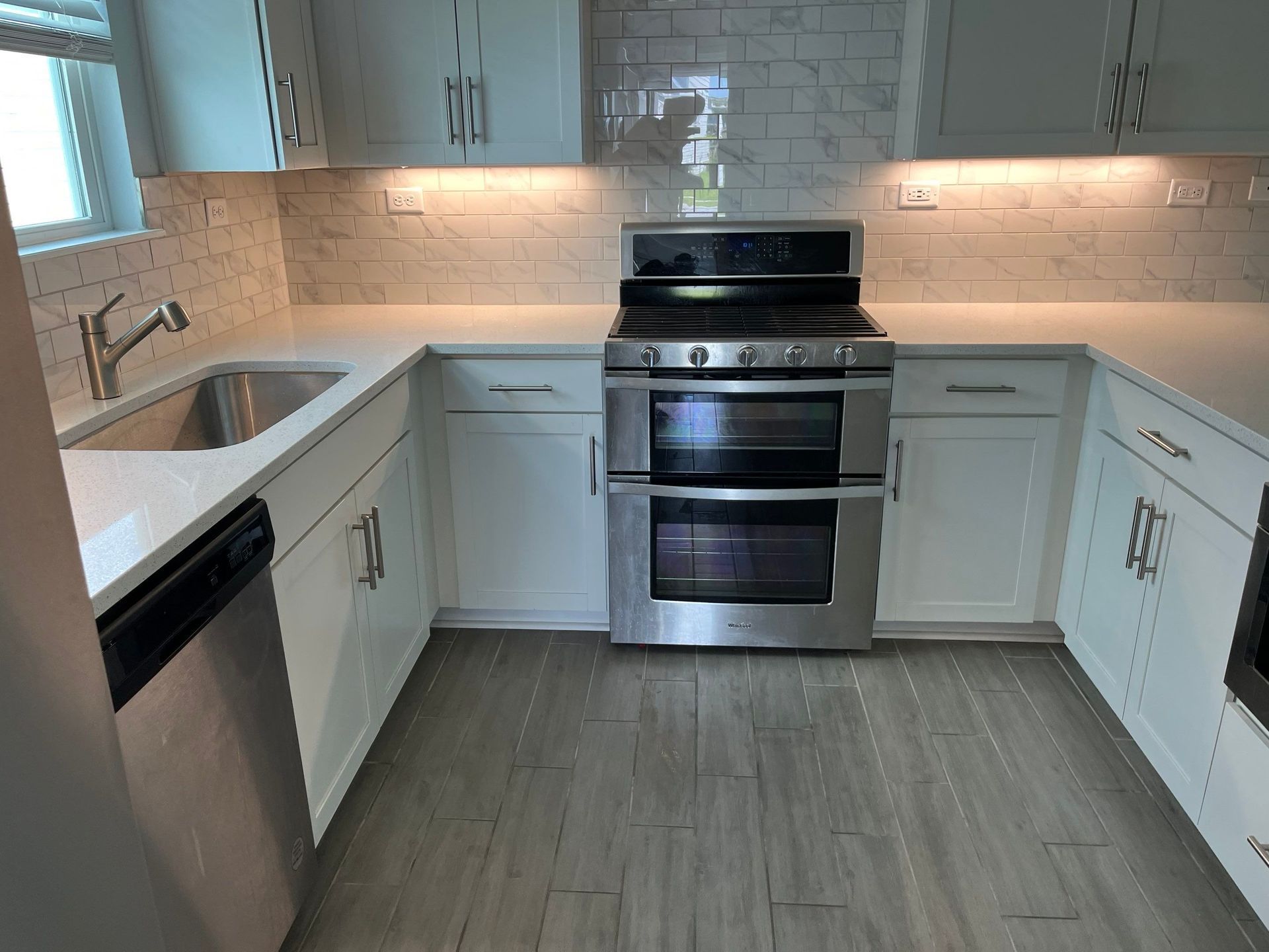 A kitchen with stainless steel appliances and white cabinets