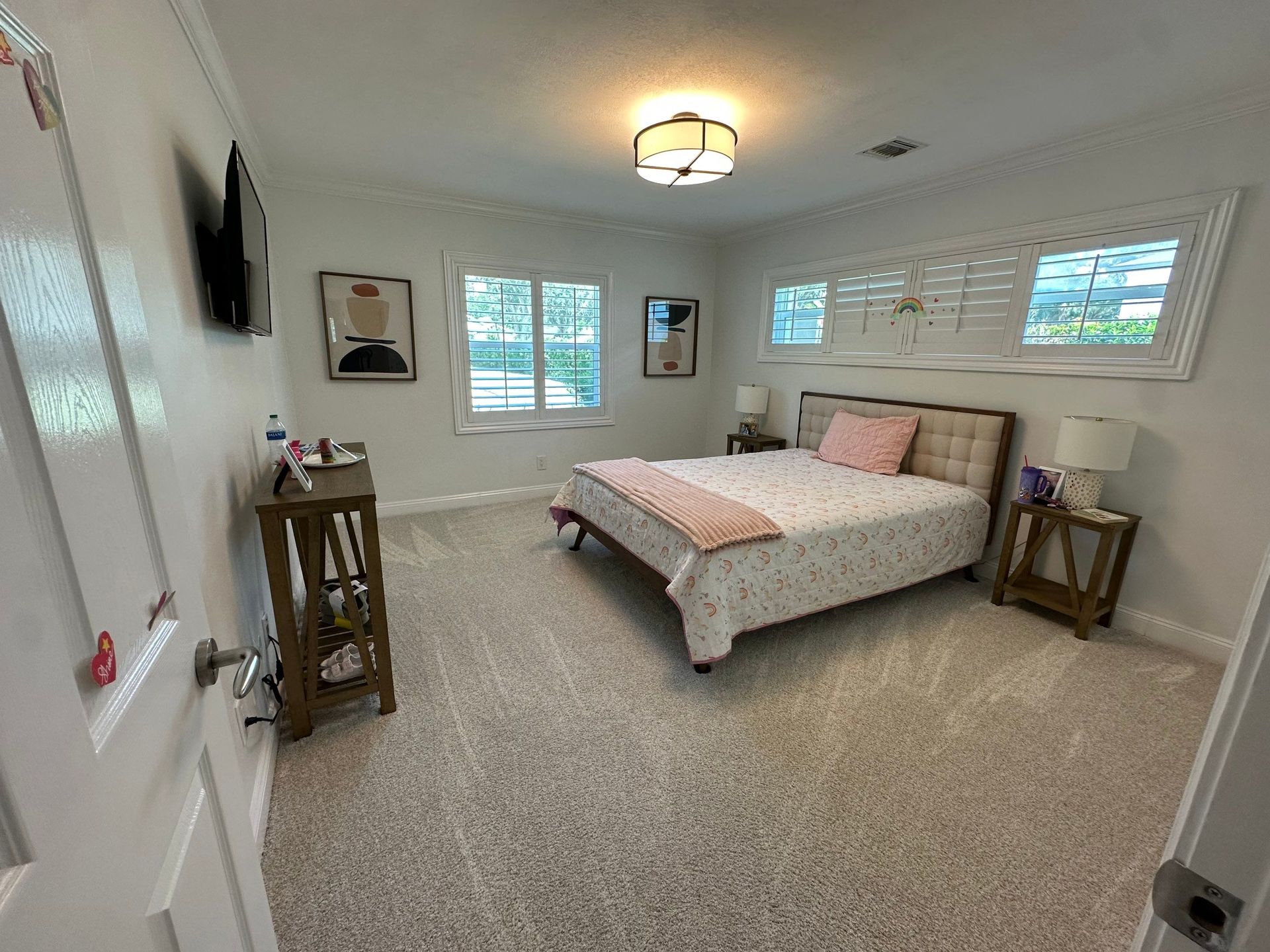 A bedroom with a bed , nightstands , and a television.